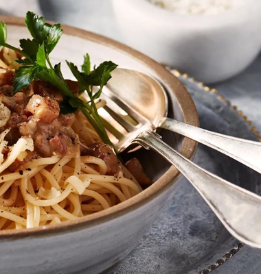 Pasta carbonara betyder kolarhustruns pasta och syftar på svartpepparn som rätten ska krönas med. Foto: Arla.